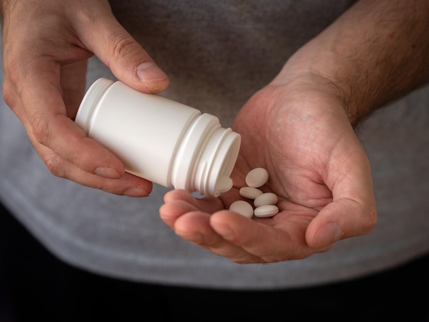 Foto behandeling en preventie van ziekten, een pot medicijnen in mannenhanden.