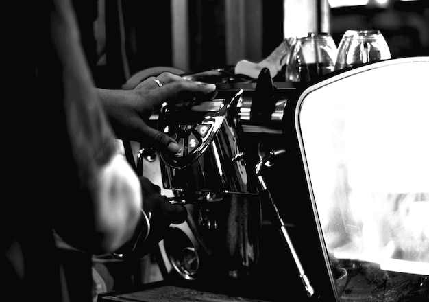 写真 客にサービスを提供するためにコーヒーマシンでコーヒーを作ったバリスタの後ろのショット