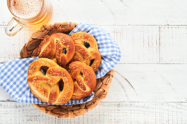 Beierse pretzels en glas pils Oktoberfest-voedselmenu traditionele gezouten pretzels over oude witte houten achtergrond Bovenaanzicht met ruimte voor tekst Oktoberfest-thema