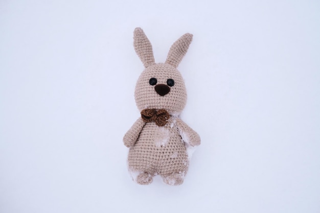 Foto coniglio amigurumi beige con orecchie lunghe e naso marrone e papillon