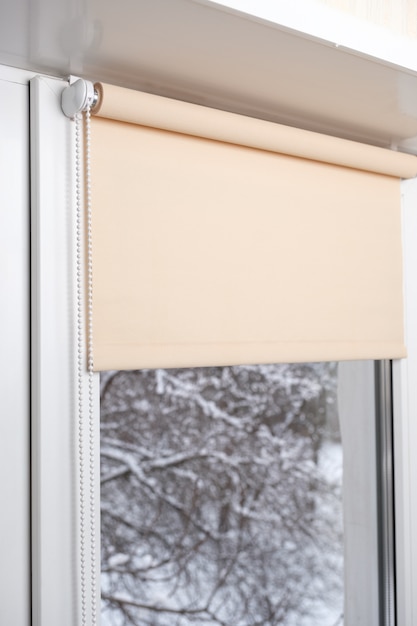 Фото Бежевые светонепроницаемые шторки на белом пластиковом окне. жалюзи на пластиковые окна.
