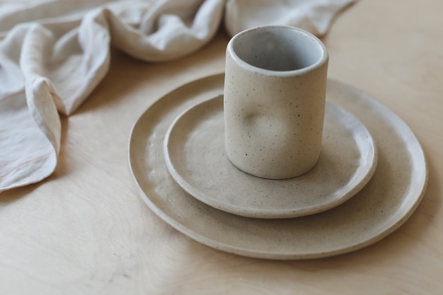 Beige ceramic plate on a wooden table top view. minimalist handmade ceramic tableware and pottery