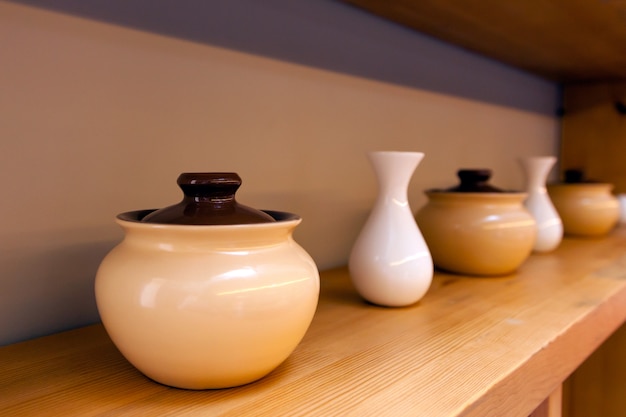 Beige ceramic pots and white small vases 