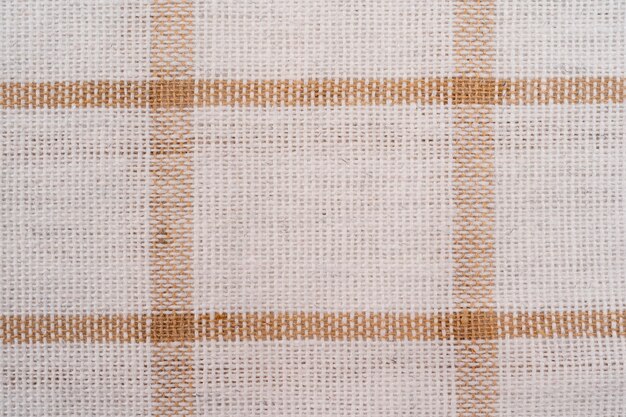 beige checkered fabric with white colored threads. fabric for plaid coat and suit. close-up