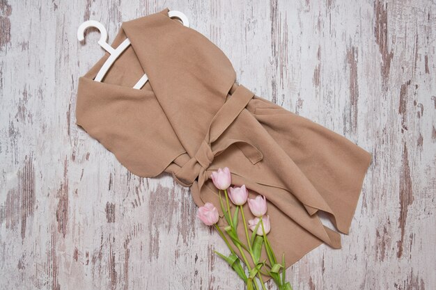 Foto cappotto beige con cintura e tulipani rosa