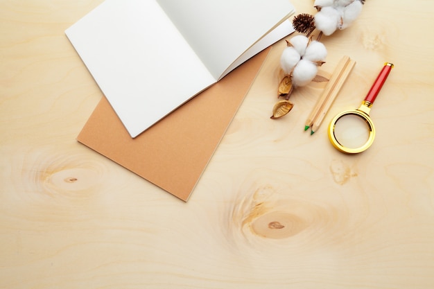 Beige color modern workplace on wooden table with a lot of things on it. Top view