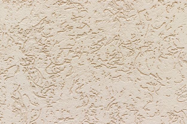 Foto struttura della parete dello stucco di cemento beige con motivo astratto