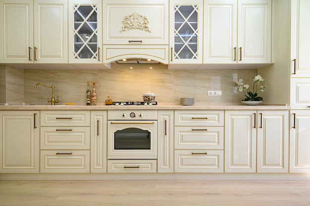Beige contemporary classic kitchen interior designed in provence style, front view to facade