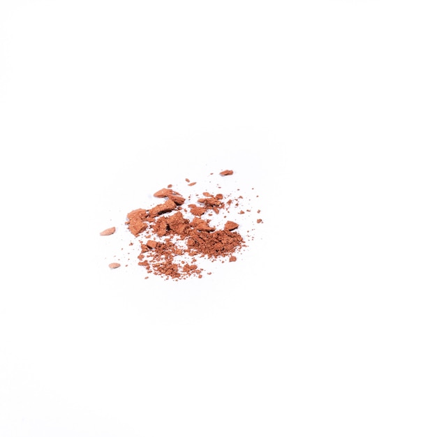 Beige crushed eye shadow isolated on white surface.