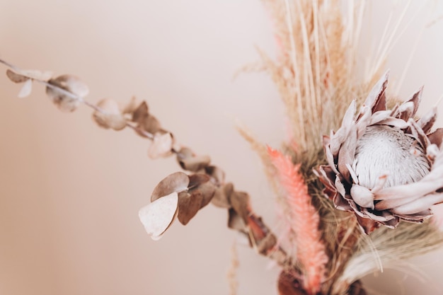 Beige flower arrangement of flowers and dried flowers