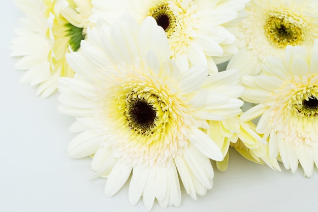 Beige gerbera's op houten tafel close-up