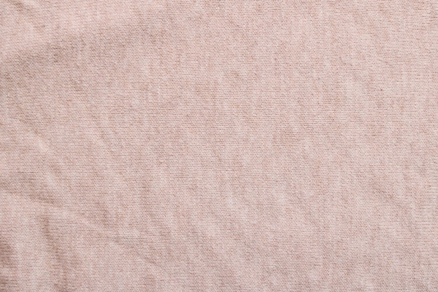 Photo beige knitted fabric closeup background or texture