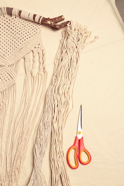 Photo beige macrame tapestry detail and scissors