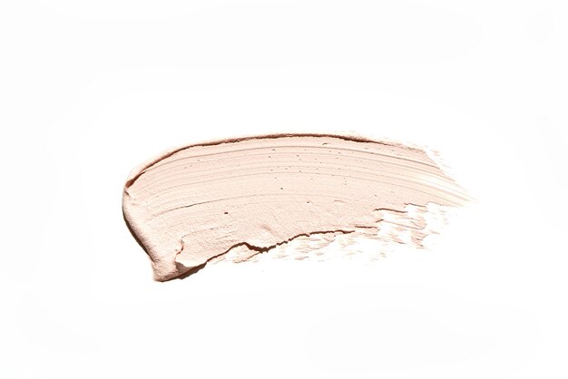 Beige make-up romige foundation uitstrijkje geïsoleerd op een witte achtergrond. huidcosmeticastaal, lichtbruine crème penseelstreek. smudge textuur van gezicht bronzer product of bb foundation