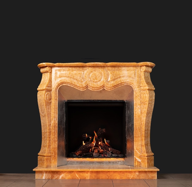 Beige marble luxury fireplace with burning wood on black