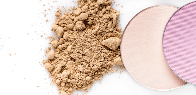 Photo beige powder for the face and round eye shadow on a white background