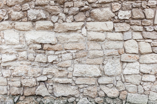 Beige rough stone rock wall. texture, old style,\
background