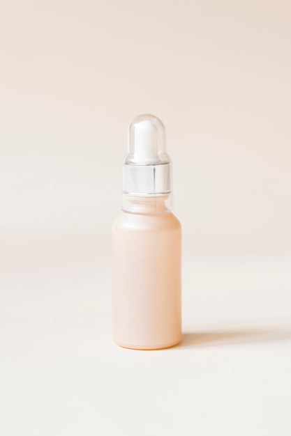 Beige serum container on cream background