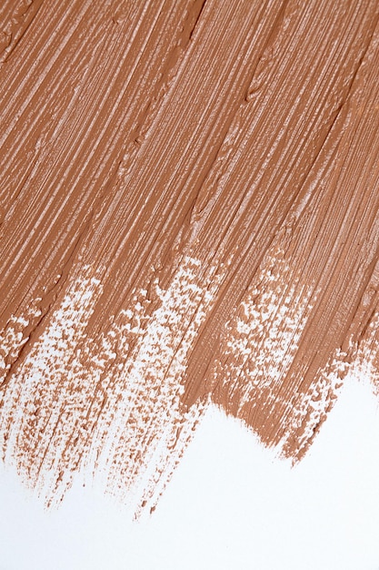 Foto macchia beige di carta da parati color crema per fondotinta tono su tono. prodotti cosmetici per il trucco e il concetto di cura della pelle