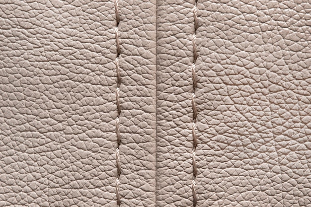 Beige stitched leatherette closeup as a background