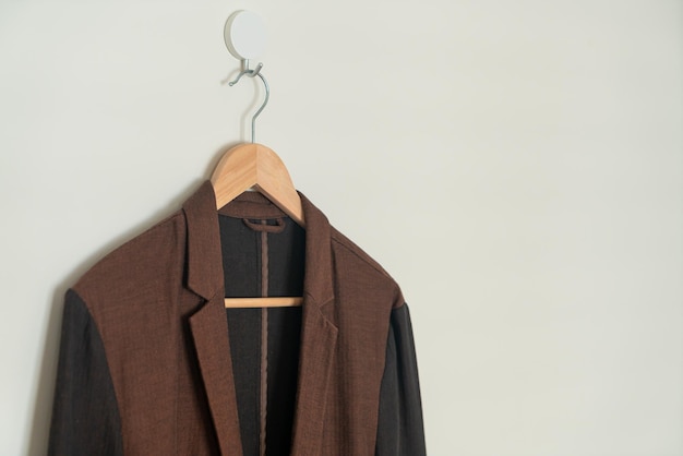 beige suit hanging with wood hanger