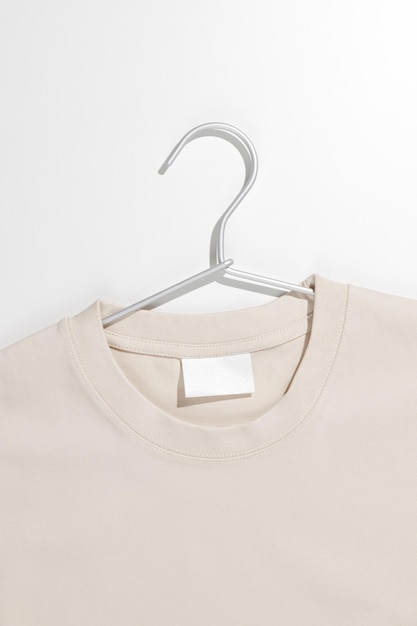 Beige t-shirt met blanco label op een kledingrek Ecologieconcept Mockup