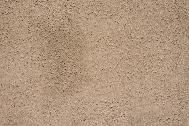 Beige textured wall, background. Structural plaster coated with water-based acrylic paint. Rough, uneven surface beige. Copy space