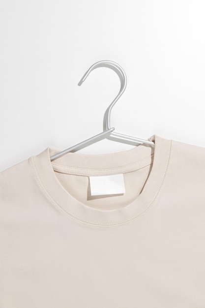 Beige tshirt with blank label on a clothes rack Ecology concept Mockup