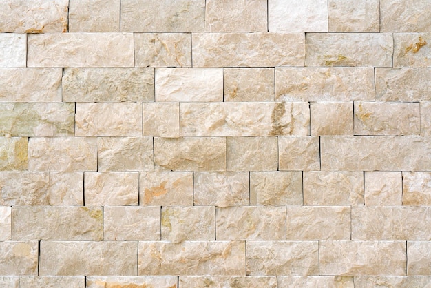 石のタイルの背景テクスチャが並ぶベージュの壁