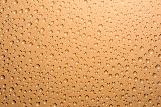 Beige water drops on the glass