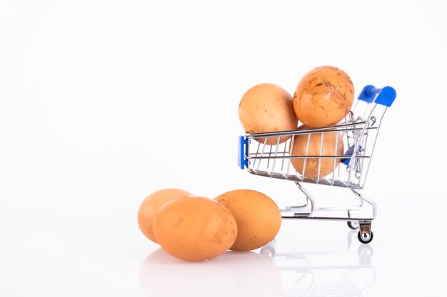 Beige, wilde kippeneieren in de mand van een shopper op een witte achtergrond. Selectieve aandacht. Ruimte kopiëren.