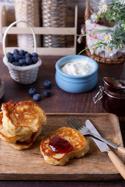 Beignets met zure room, jam en bosbessen. Het traditionele Russische gerecht. Detailopname.