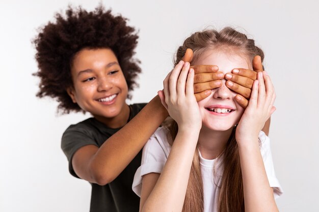 Being blindfolded. Childish dark-haired boy being tricky and playing with his friend while she touching him