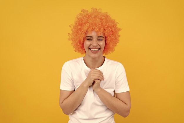 Being in a good mood happy lady having fun going crazy fancy party look freaky woman in clown wig on yellow background express positive emotions funny girl in orange wig april fools day