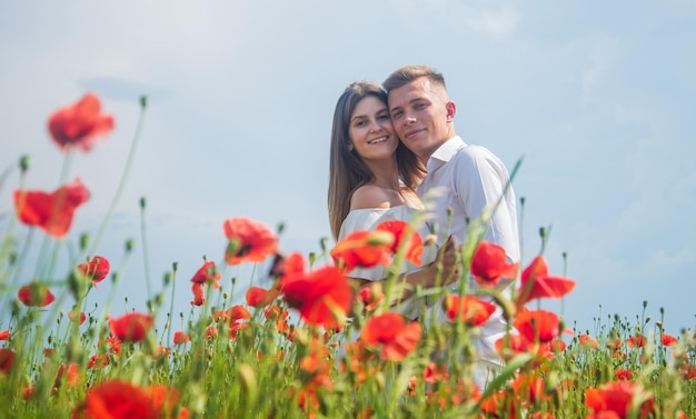 Being in love summer vacation happy family among red flowers\
spring nature beauty love and romance romantic relationship\
beautiful couple in love man and woman in poppy flower field