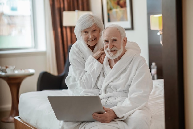 Bejaard echtpaar in een hotelkamer met plezier