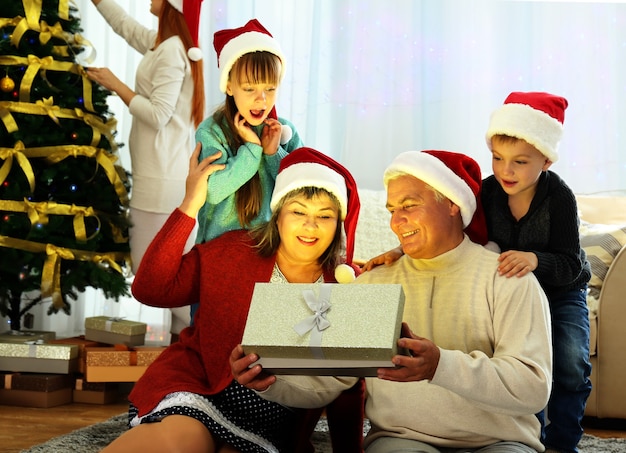 Bejaard echtpaar opent kerstcadeau in woonkamer