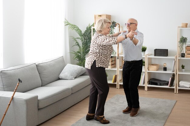 Bejaard paar dat in de woonkamer danst