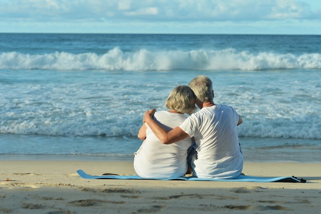 Bejaard paar dat op strand loopt