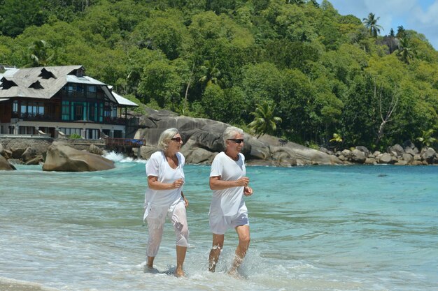 Bejaard paar dat op strand loopt