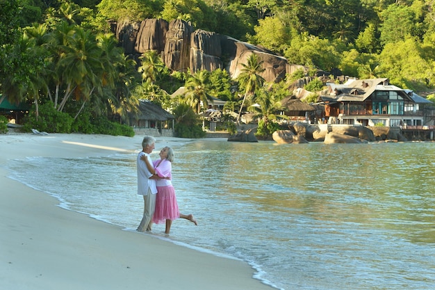 Bejaard paar die op strand rusten Travel