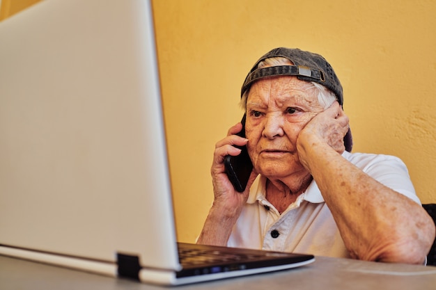 Foto bejaarde die van huis werkt