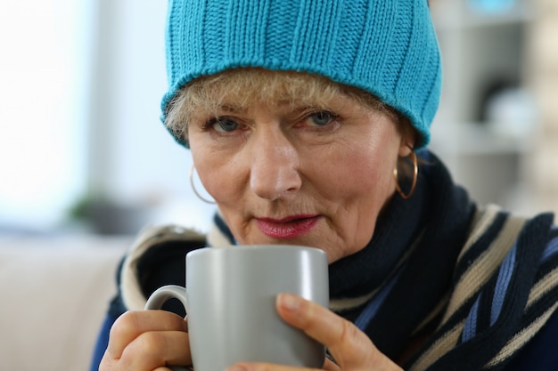 Bejaarde die ziek voelt en thee drinkt