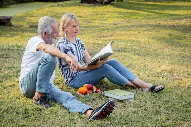 Bejaarde echtpaar op het gras in het park