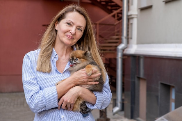 Foto bejaarde gepensioneerde vrouw lopen park kleine hond