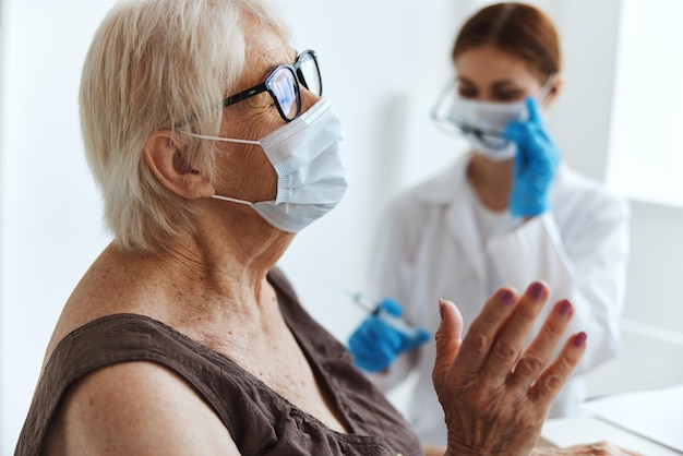 Bejaarde vrouw met een medisch masker immunisatie veiligheid gezondheidszorg Foto van hoge kwaliteit