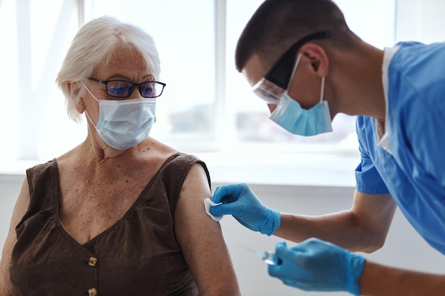 Foto bejaarde vrouw met medisch masker injectie coronavirus covid19 paspoort