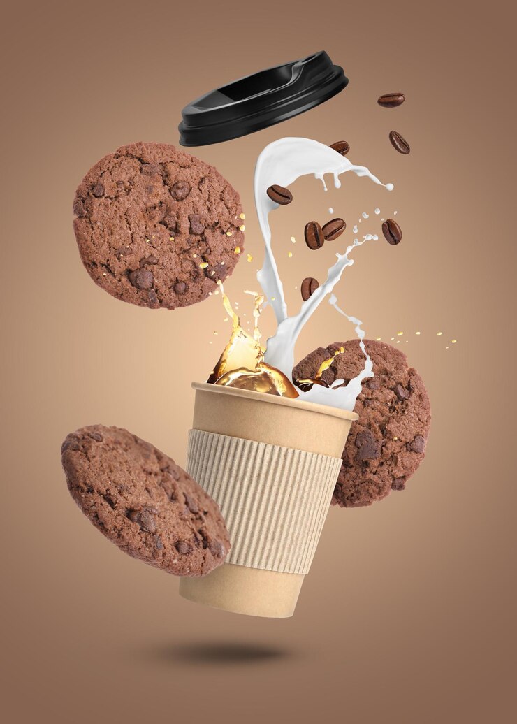 Foto beker koffie, chocoladekoekjes en geroosterde bonen vliegen op een lichtbruine achtergrond.