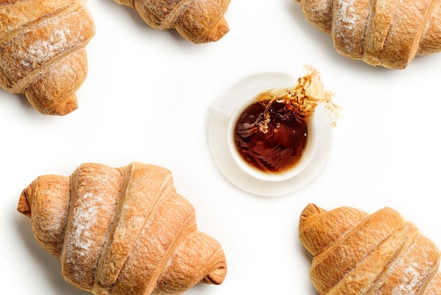 Beker met koffie en croissants geïsoleerd op witte achtergrond koffie morst uit de beker