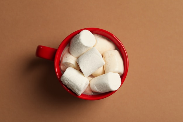 Beker met marshmallows op bruine achtergrond, bovenaanzicht
